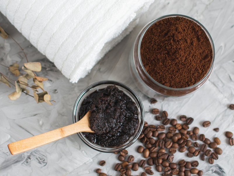 Coffee grounds in glass jar with wooden spoon